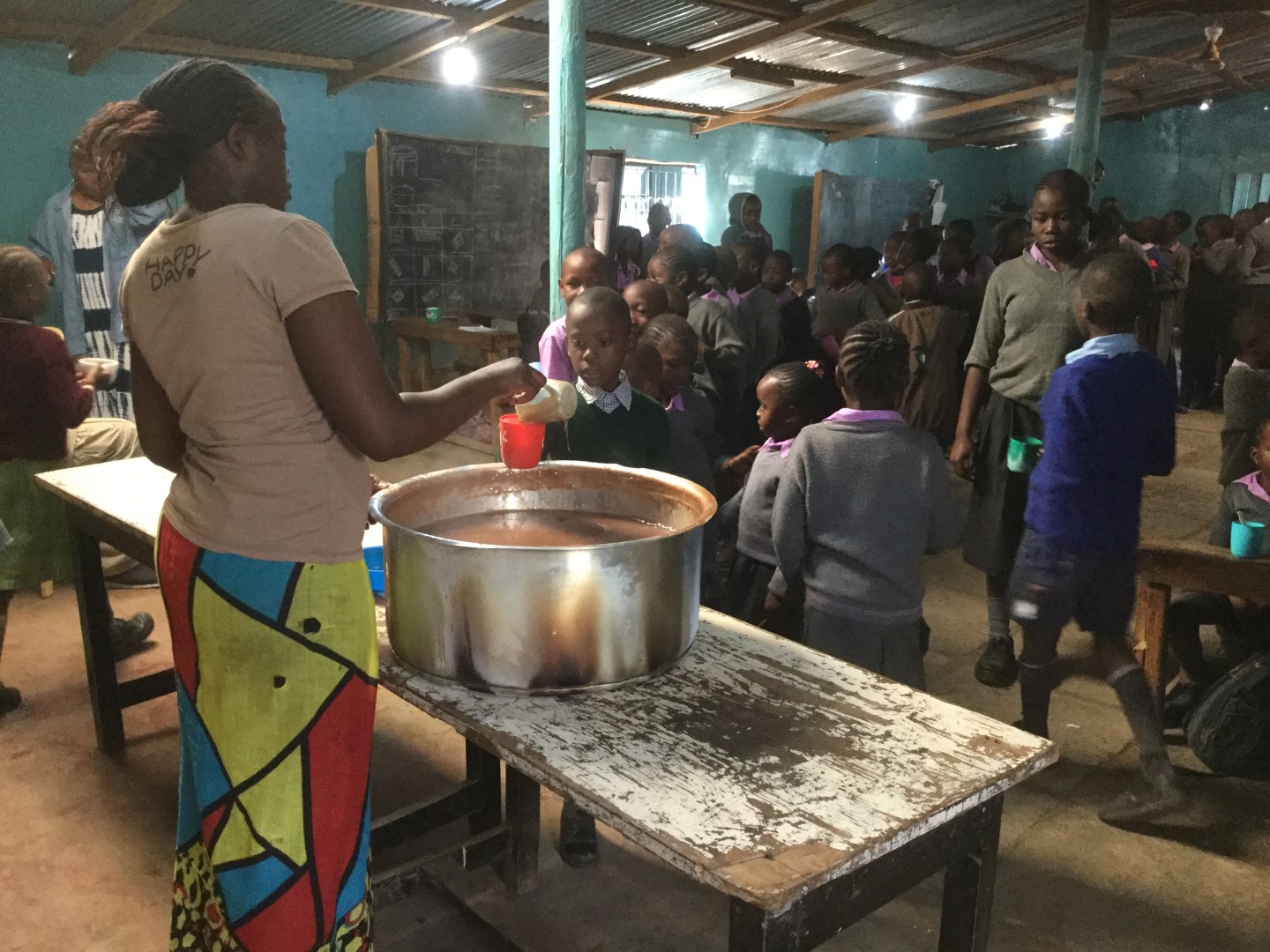 Students gathered around a shared meal in their classroom.